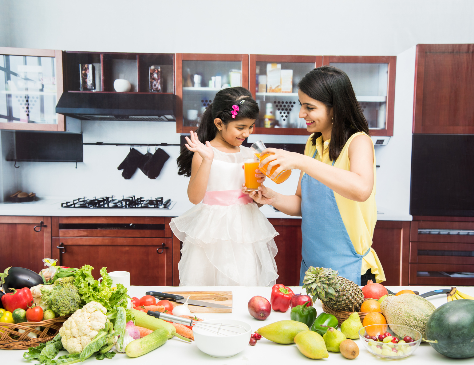 Beautiful Indian Asian Young Mother Daughter Kitchen With Table Full Fruits Vegetable at Core Concept