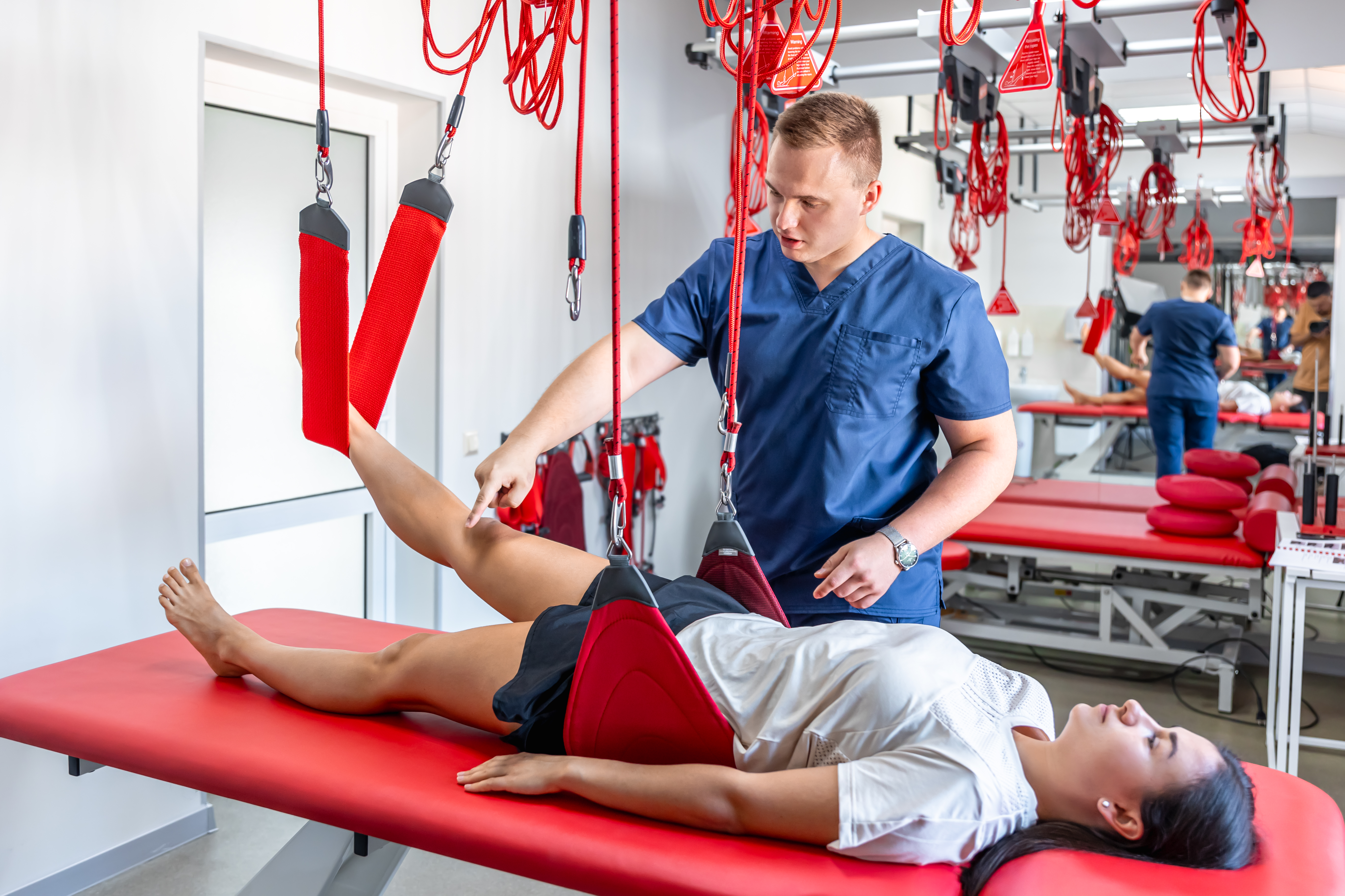 rehabilitation specialist doing treatment suspension straps patient at Core Concept
