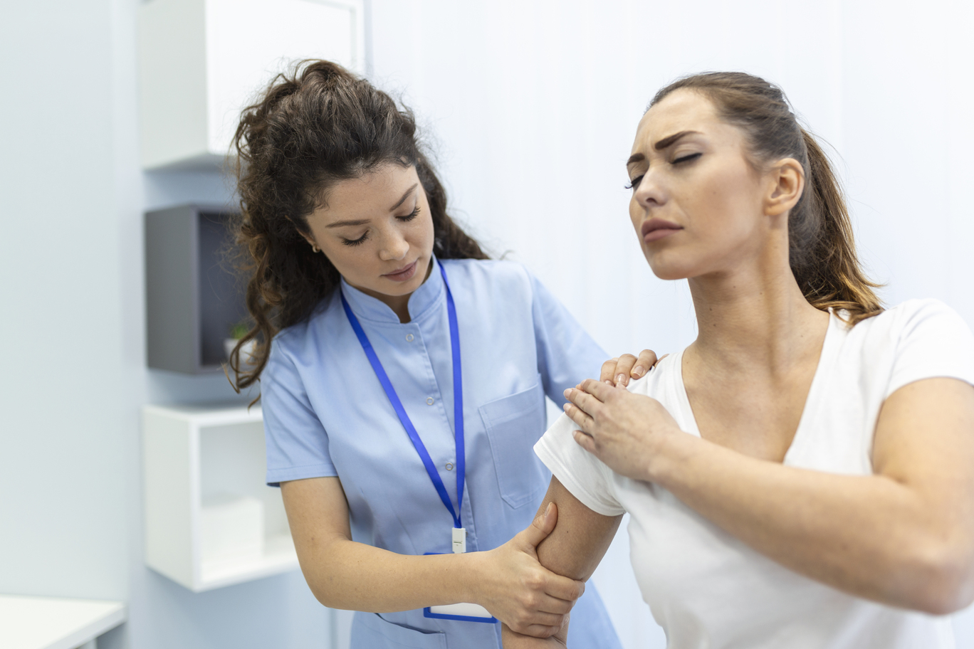 woman doctor osteopath medical uniform fixing woman patients shoulder back joints manual therapy clinic visit professional osteopath work with patient concept at core concept