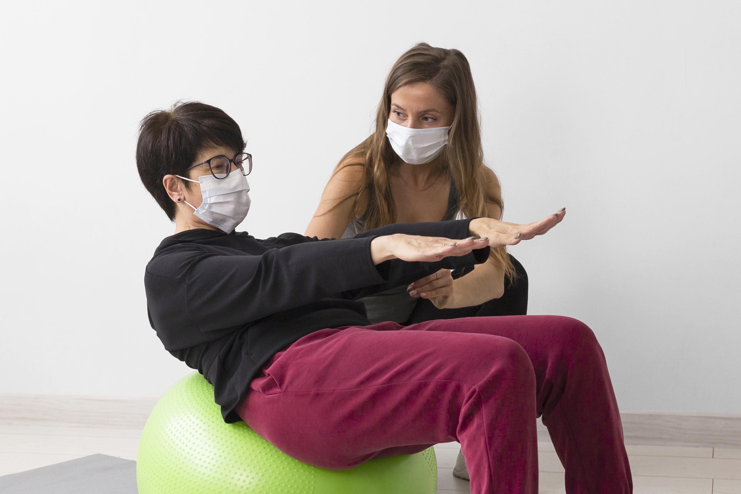 Woman Training Fitness Ball While Wearing Medical Mask at Core Concept